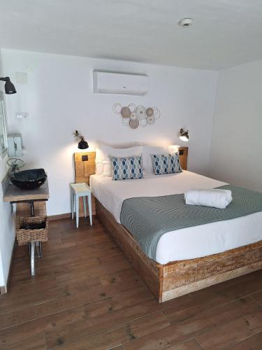 a bedroom with a large bed and a desk at Lovin Book Guesthouse in Óbidos
