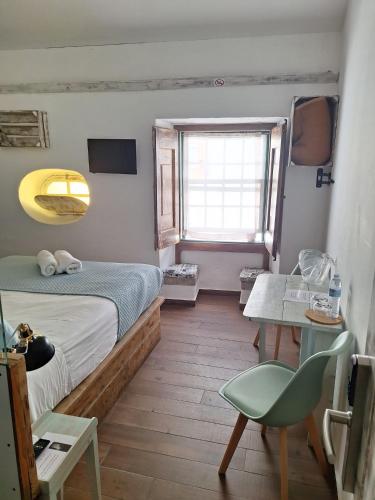 a bedroom with a bed and a table and a window at Lovin Book Guesthouse in Óbidos