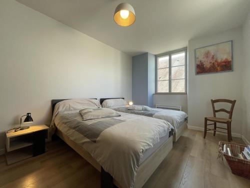 a bedroom with two beds and a table and a chair at Chez zézé in Asson