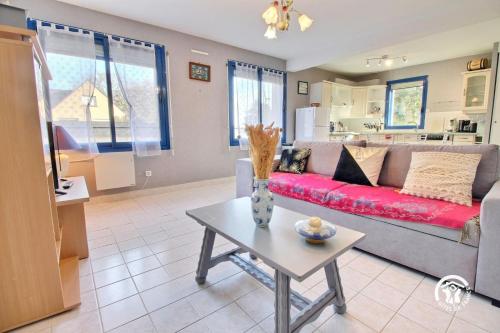 un salon avec un canapé rouge et une table dans l'établissement Les arums, à Baden