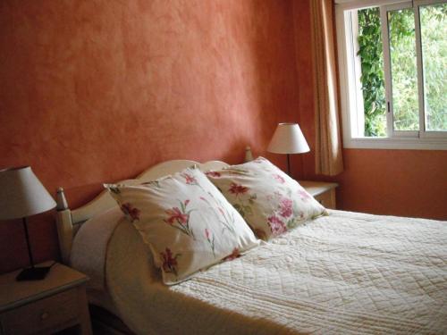 - une chambre avec un lit avec deux oreillers et une fenêtre dans l'établissement La cigaline, à Bagnols-en-Forêt