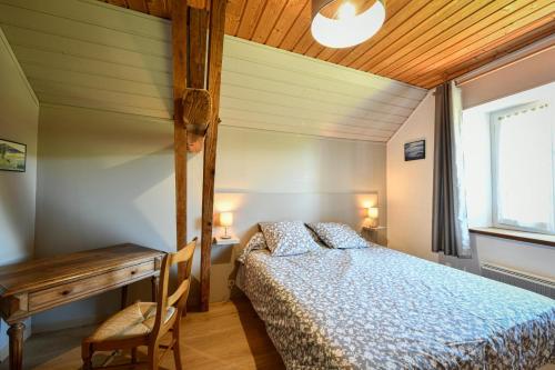 a bedroom with a bed and a table and a desk at Chez evon in Jurançon
