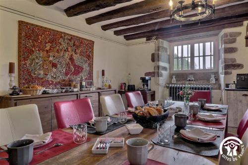 a dining room with a table and red chairs at Chateau de la giraudais in Mézières-sur-Couesnon