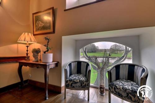 a room with two chairs and a table and a window at Chateau de la giraudais in Mézières-sur-Couesnon