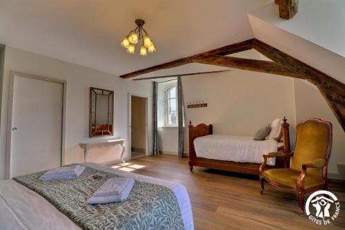 a bedroom with two beds and a chair in it at Chateau de la giraudais in Mézières-sur-Couesnon