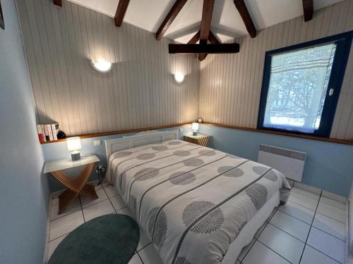 a bedroom with a large bed and a window at Peyrot in Onesse-et-Laharie