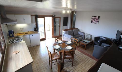 a kitchen and a living room with a table and chairs at Chez forcade in Lanne en Barétous