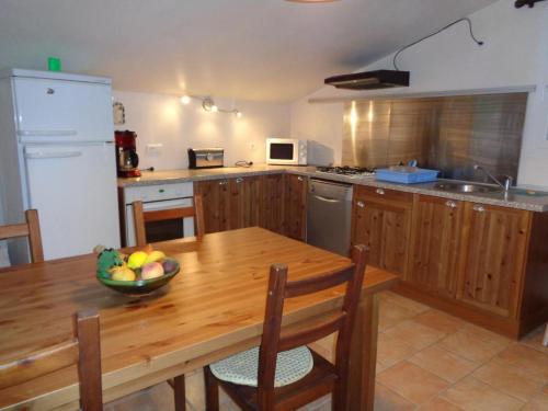- une cuisine avec une table en bois et un bol de fruits dans l'établissement Gite en campagne g2072, à Gonfaron