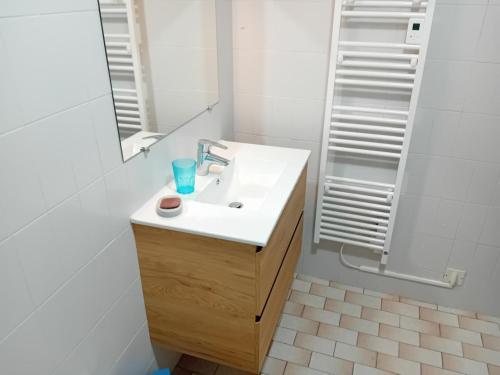 a white bathroom with a sink and a shower at Gîte jean in Horsarrieu