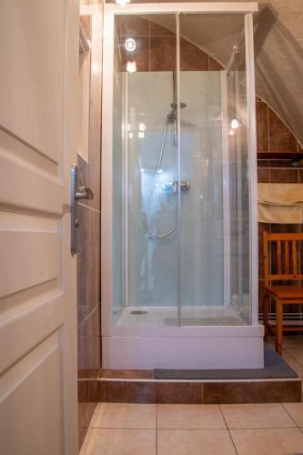 une douche avec une porte vitrée dans une salle de bain dans l'établissement La maison d'elise, à Les Bondons