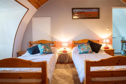 2 lits dans une chambre avec 2 lampes sur des tables dans l'établissement La maison d'elise, à Les Bondons