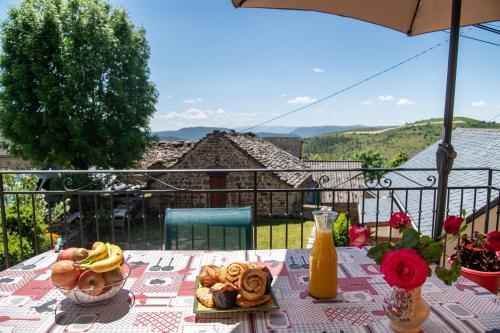 une table avec une assiette de nourriture sur un balcon dans l'établissement La maison d'elise, à Les Bondons