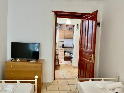 a living room with a tv and a dresser with a television at Kassandra House in Hydra