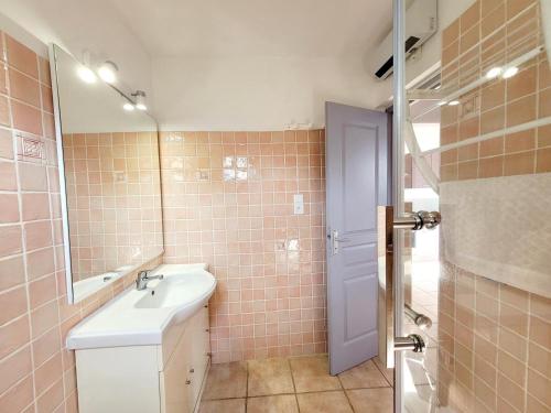 une salle de bain avec un lavabo et un miroir dans l'établissement Maison arboree de 39 m2 - piscine et plage a 400m -, à Six-Fours-les-Plages