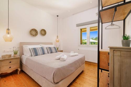 a bedroom with a bed with two towels on it at Villa Stamatella by Villa Plus in Velonádes