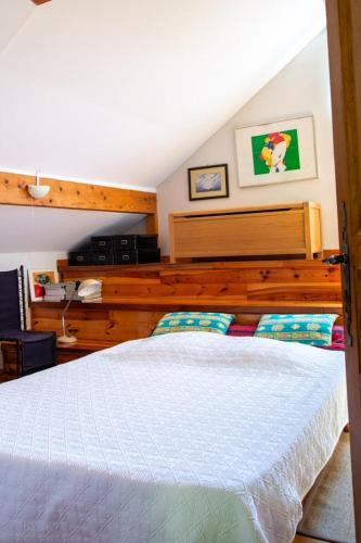 une chambre avec un lit blanc avec une tête de lit en bois dans l'établissement Gîte Gîte Les Combettes 2/3 personnes, à Ispagnac