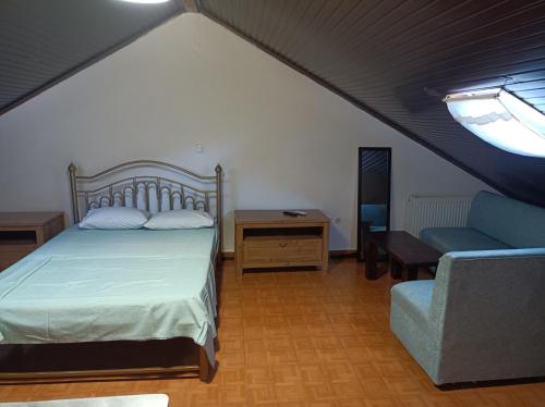 a bedroom with a bed and a couch and a window at Blue Moon Apartments in Nea Michaniona
