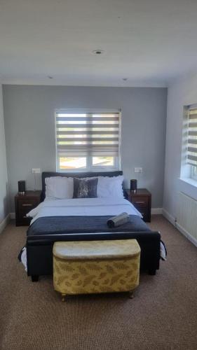 a bedroom with a large bed and two windows at Doncaster Dream House Retreat- Sleeps 9 in Doncaster