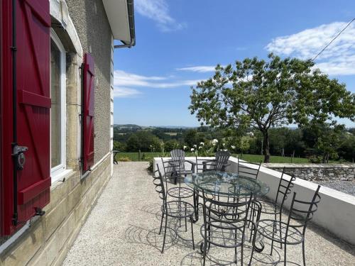 a patio with chairs and a glass table on a balcony at Larrouy in Asson