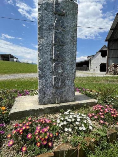 a stone monument in a garden with flowers at Larrouy in Asson