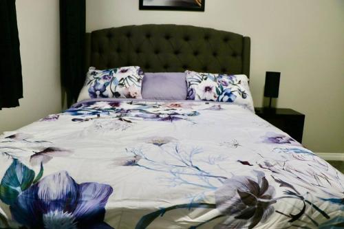 a bedroom with a bed with a floral bedspread at Parkside Luxury Stay with Xbox Entertainment in Calgary
