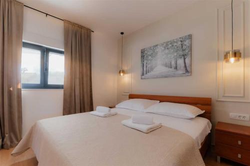 a bedroom with a bed with two towels on it at Villa Amare in Donji Zemunik