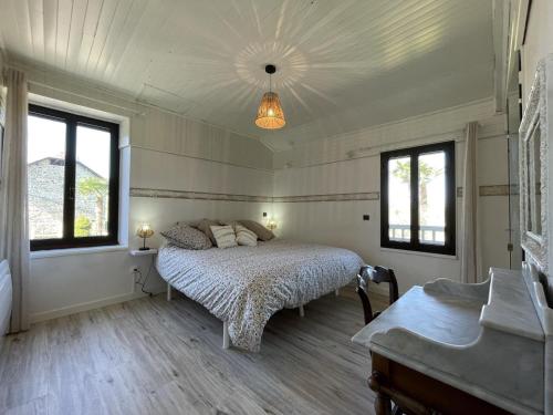 a bedroom with a bed and two windows at Cyralie in Asson