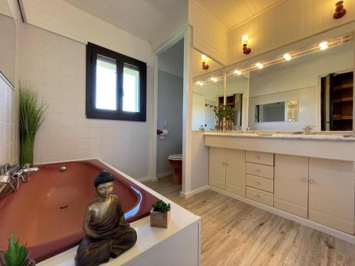a bathroom with a buddha statue sitting in a tub at Cyralie in Asson