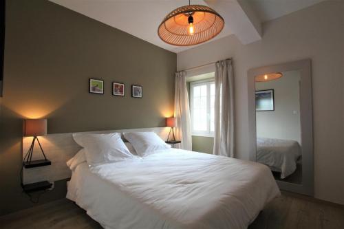 a bedroom with a large white bed and a window at Labourdette in Lasseube