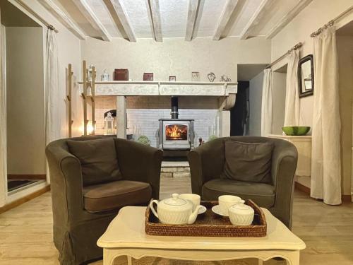 a living room with two chairs and a fireplace at Labourdette in Lasseube