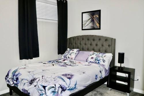 a bedroom with a bed with a purple and white comforter at Parkside Luxury Stay with Xbox Entertainment in Calgary