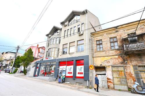 a man walking down a street in front of a building at Easy Apartments in Kumanovo