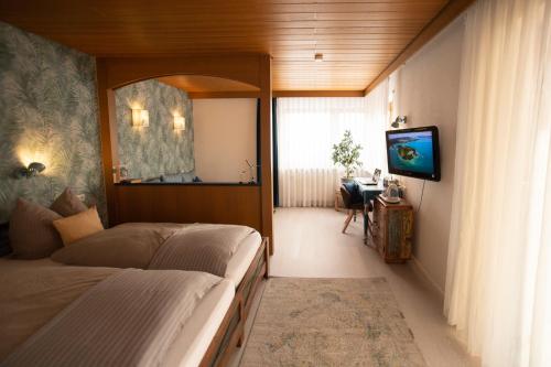 a bedroom with a bed and a television in it at Haus Rose in Allensbach