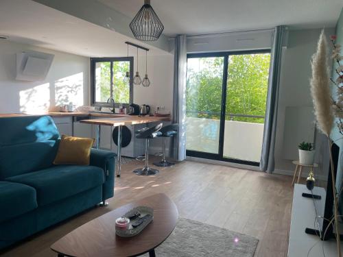 un salon avec un canapé bleu et une table dans l'établissement Charmant appartement à Bordeaux, à Bordeaux