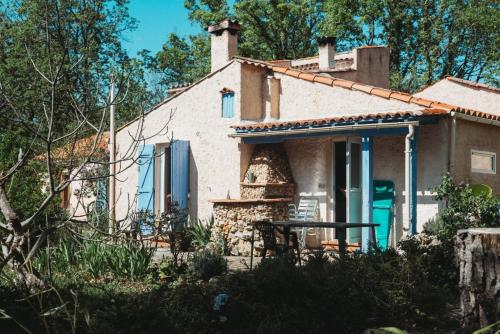 a small white house with a table in front of it at Gite au calme l'eclaircie in Régusse