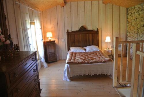 une chambre avec un lit dans une pièce aux murs en bois dans l'établissement Le mas des valettes, à Pontevès