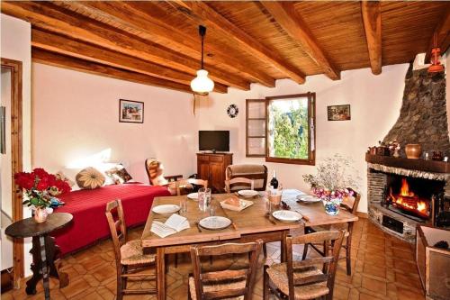 - un salon avec une table, un lit et une cheminée dans l'établissement Gîte Clévacances 2 clés 4/6 personnes, à Saint-André-de-Lancize