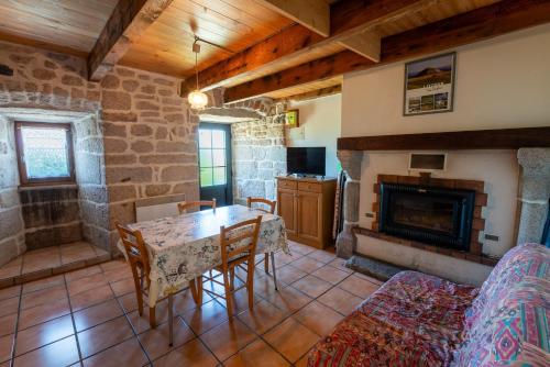 un salon avec une table et une cheminée dans l'établissement Location 2 personnes aux badieux, à Les Badieux