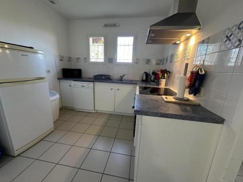 a kitchen with white cabinets and a counter top at Marensin in Mugron