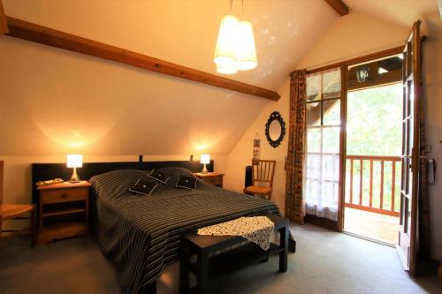 a bedroom with a bed and a table and a window at Cauhape in Auga