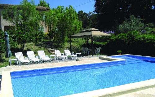 - une piscine avec des chaises, un parasol, une table et des chaises dans l'établissement Villa la desirade, à Cotignac