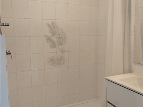 La salle de bains est pourvue d'une douche et d'une plante murale. dans l'établissement Studio Alcôve - Face au Chenal, 50m Plage/Port, 700m Centre-Ville, Capacité 3 pers., Confort Moderne - FR-1-331-202, à Les Sables-dʼOlonne