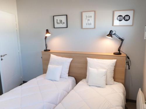 two beds in a room with white pillows at Appartement PMR 2 Chambres, Face Plage, Piscine, Balcon, Pour 6 Personnes, Animaux Admis - FR-1-194-222 in La Tranche-sur-Mer