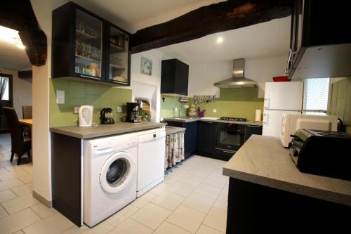 a kitchen with a washing machine in the middle at Les moissonneurs in Champagnac-la-Rivière