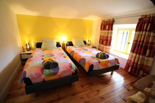 a bedroom with two beds and a yellow wall at Les moissonneurs in Champagnac-la-Rivière