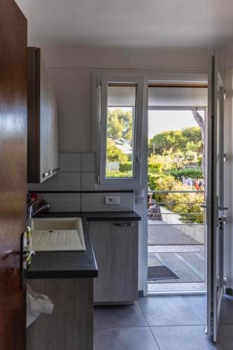 d'une cuisine avec évier et d'une fenêtre avec vue. dans l'établissement Villa a 100 m de la mer, à Six-Fours-les-Plages