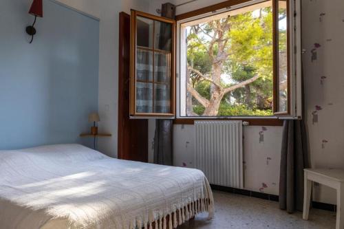 une chambre avec un lit et une grande fenêtre dans l'établissement Villa a 100 m de la mer, à Six-Fours-les-Plages