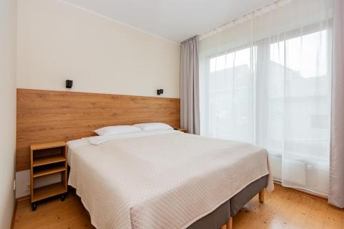a bedroom with a bed and a large window at Smilciu 34 in Palanga