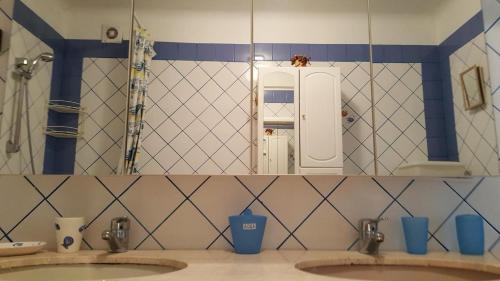 une salle de bain avec deux lavabos et un grand miroir dans l'établissement Gite au calme en campagne, à Tanneron