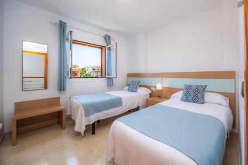 a hotel room with two beds and a window at Villa Paraíso in Alcudia